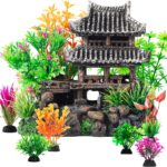 A gray resin castle aquarium decoration with arched entrances, surrounded by eight green and purple artificial aquarium plant