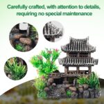 A gray resin castle aquarium decoration with arched entrances, surrounded by eight green and purple artificial aquarium plant