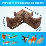 A dark brown, textured FISHNOSH aquarium cave, designed to look like natural driftwood, placed in a fish tank corner.