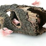A brown, textured resin tree trunk aquarium decoration with multiple holes, providing a hiding spot for small fish.