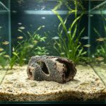 A brown, textured resin tree trunk aquarium decoration with multiple holes, providing a hiding spot for small fish.