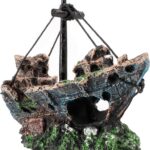 A detailed, multicolor Raeasily shipwreck resin aquarium ornament depicting a sunken vessel amidst aquatic plants, adding cha