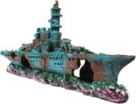 A detailed blue resin sunken ship decoration positioned within a vibrant aquarium, surrounded by green aquatic plants.