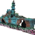 A detailed blue resin sunken ship decoration positioned within a vibrant aquarium, surrounded by green aquatic plants.