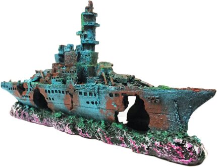 A detailed blue resin sunken ship decoration positioned within a vibrant aquarium, surrounded by green aquatic plants.