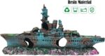 A detailed blue resin sunken ship decoration positioned within a vibrant aquarium, surrounded by green aquatic plants.