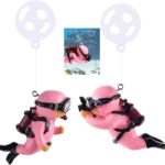 Two pink floating diver ornaments with tiny oxygen tanks and cameras, submerged in a clear fish tank with bubbles.