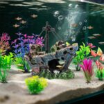 An 8-piece aquarium decoration set featuring a multicolored resin sunken ship and seven artificial green aquatic plants.
